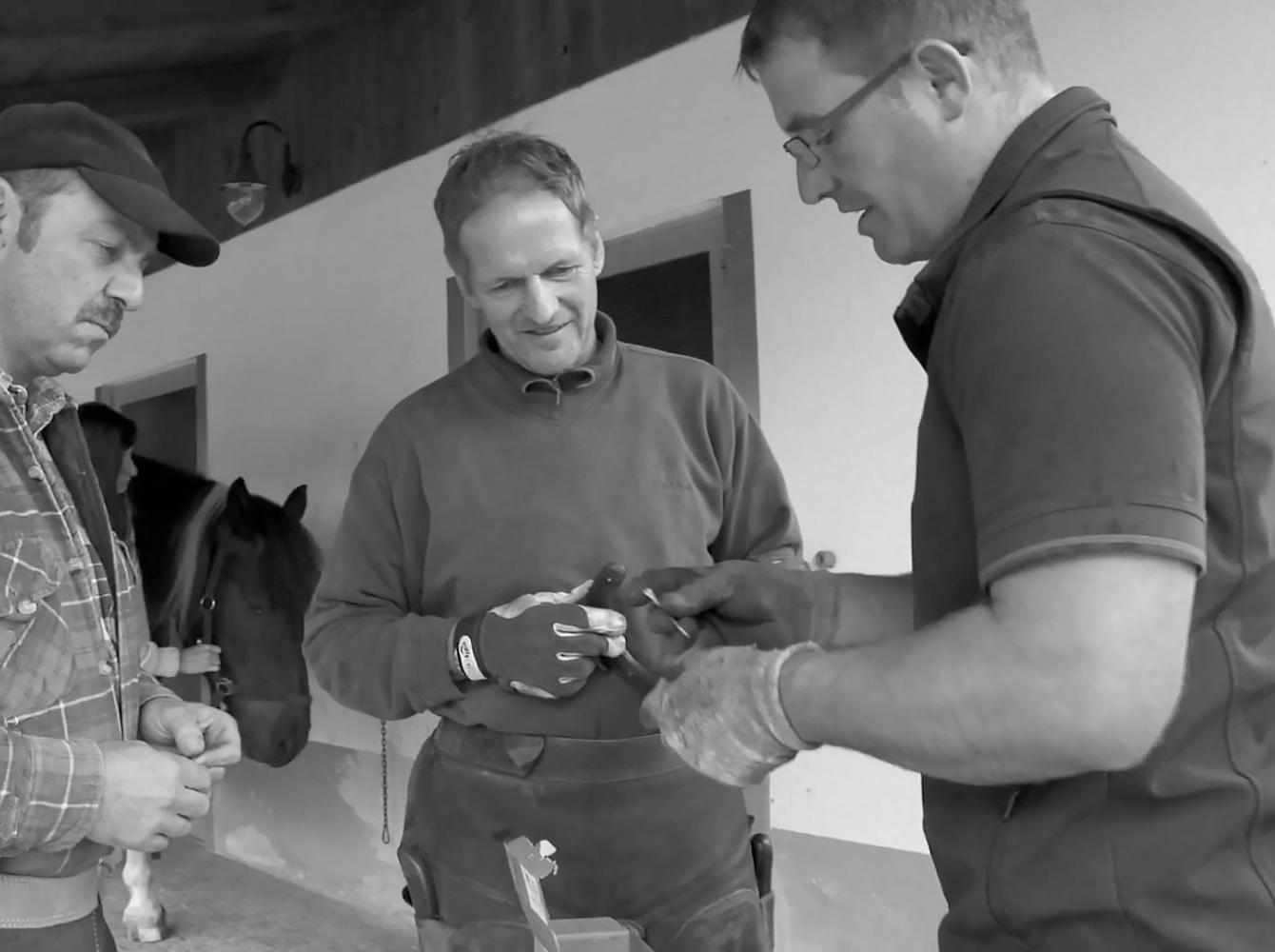 Christoph Müller talking with two farriers